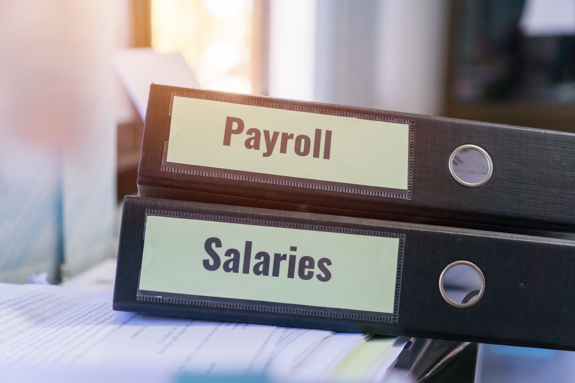 HR-human resources business and bookkeeping accountancy concept. Payroll and salaries folders stack with label on black binder on paperwork documents summary report in busy offices